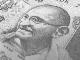 Detailed monochrome depiction of an Indian rupee banknote with Gandhi's portrait, symbolizing finance and economy.