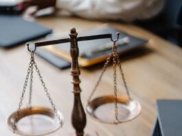 A striking image featuring a brass justice scale and gavel on a wooden desk, symbolizing law and justice.