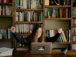 woman in black long sleeve shirt sitting in front of silver macbook