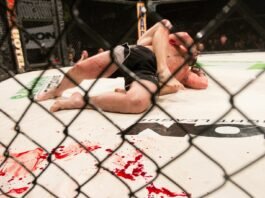 a man laying on top of a wrestling ring