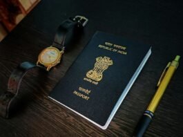 a passport, watch and pen on a table